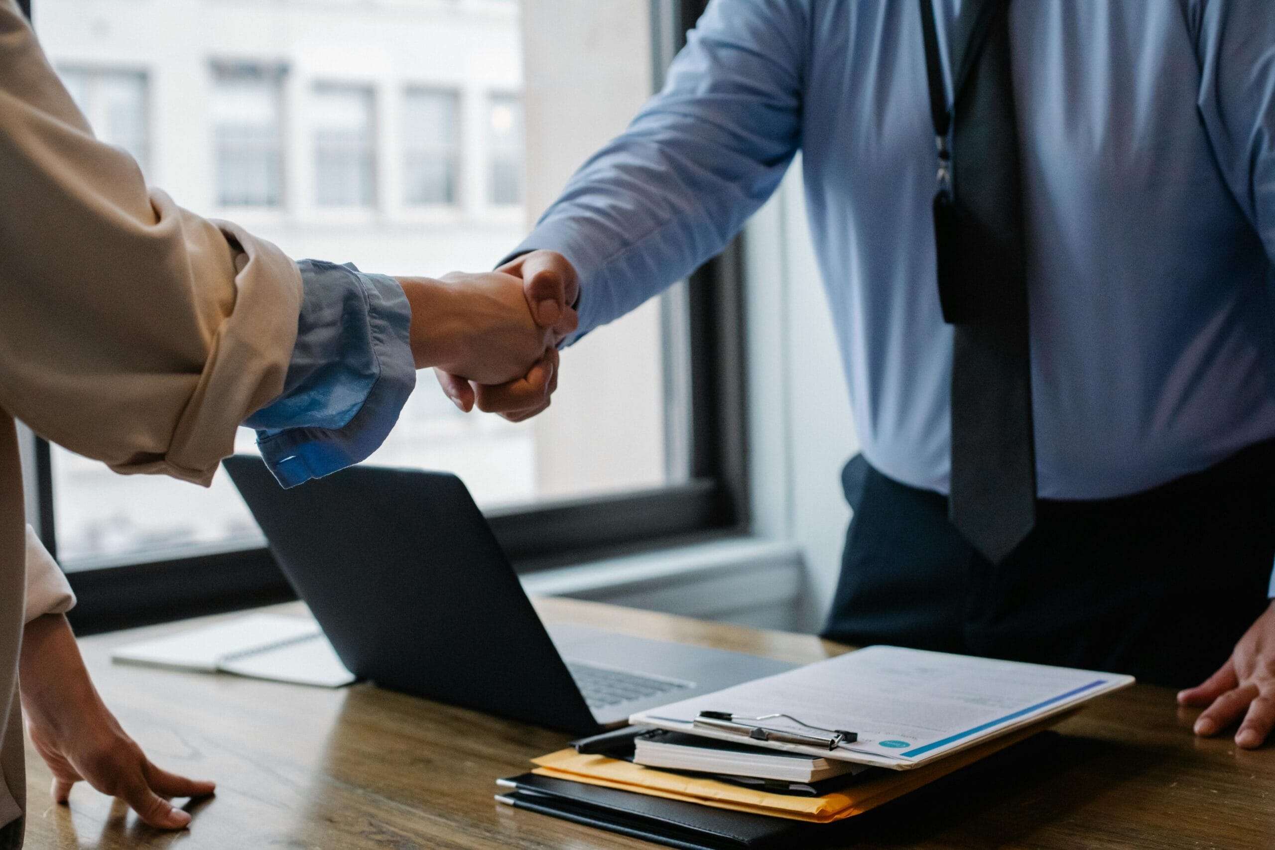 Life sciences startup founder and partner shaking hands after negotiating a licensing agreement for technology growth