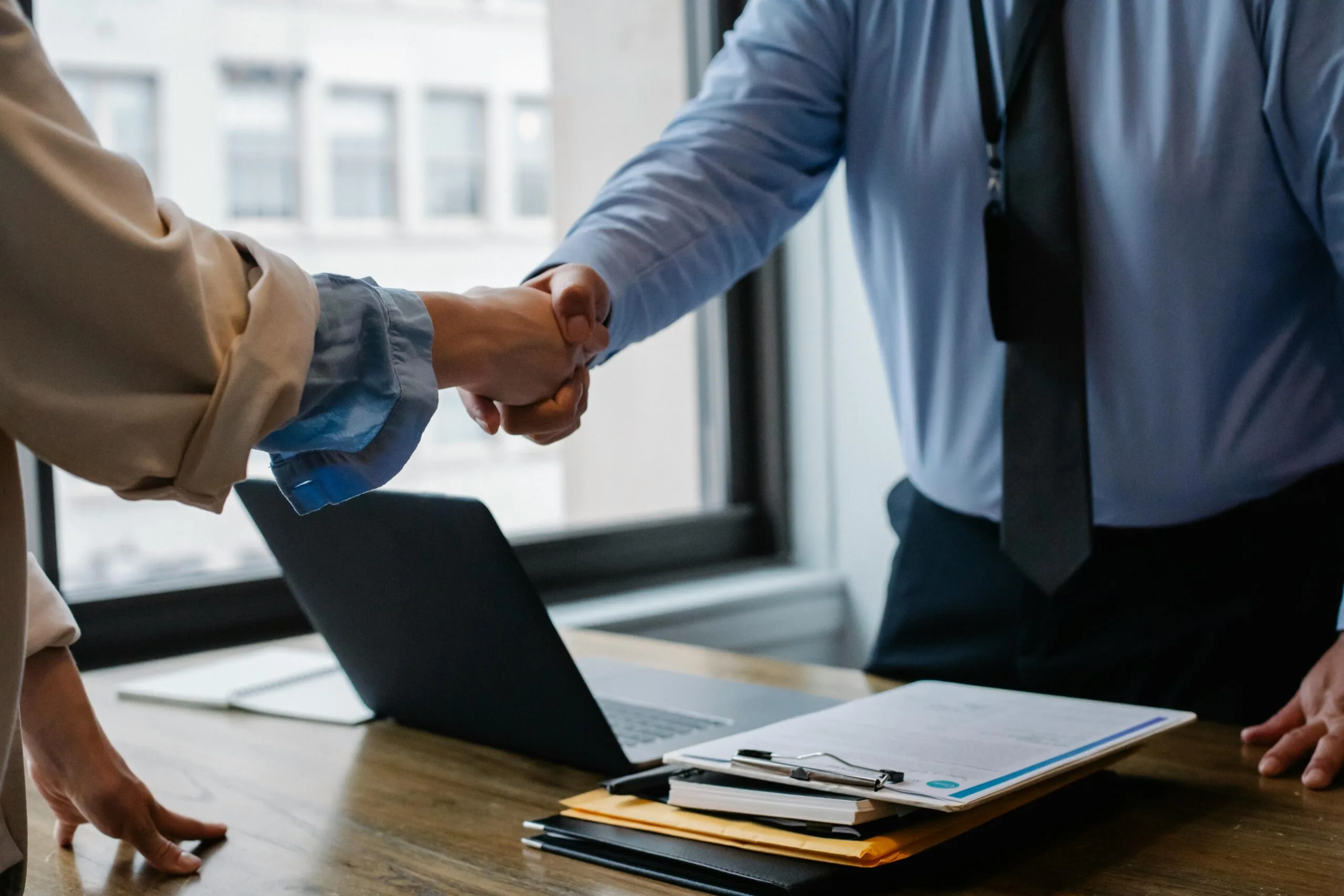 Life sciences startup founder and partner shaking hands after negotiating a licensing agreement for technology growth