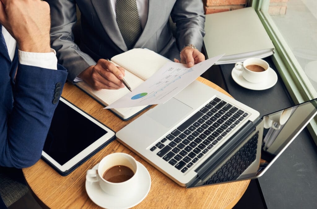Business professionals reviewing financial documents and strategies to mitigate legal risks for a tech company